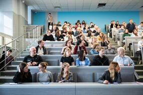 Абитуриенты и их родители слушают презентацию о программах высшего образования и специализированного высшего образования